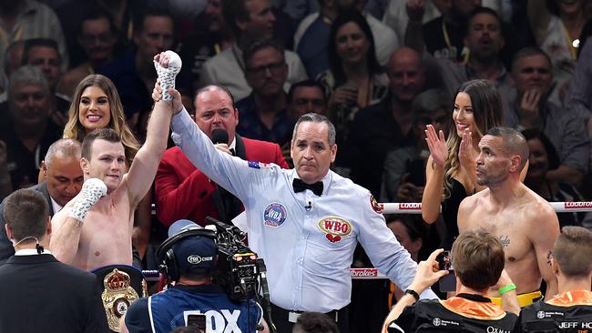 Australian boxer Jeff Horn has his arm raised as he is announced winner against Anthony Mundine (right) following the River City Rumble boxing match at Suncorp Stadium last month. (AAP Image/Dave Hunt)