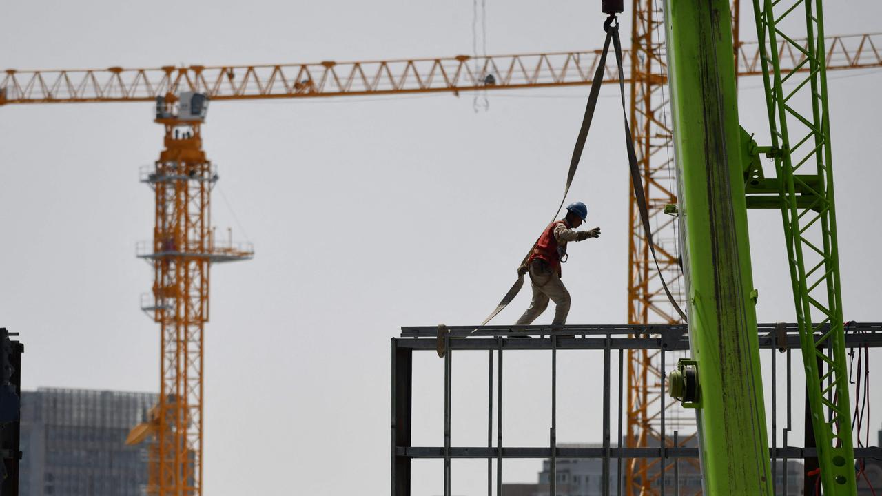 A worker walks on a steel structure at a construction site in Beijing on May 8. Picture: Greg Baker/AFP