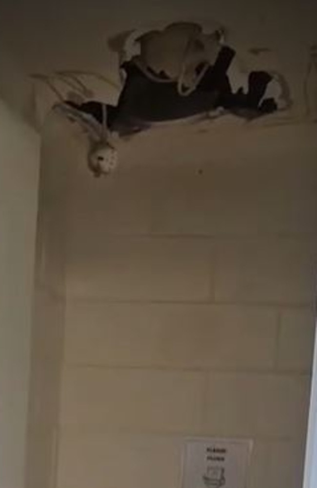 A gaping hole in the ceiling above one of the toilets at the Dingo Blue hostel.
