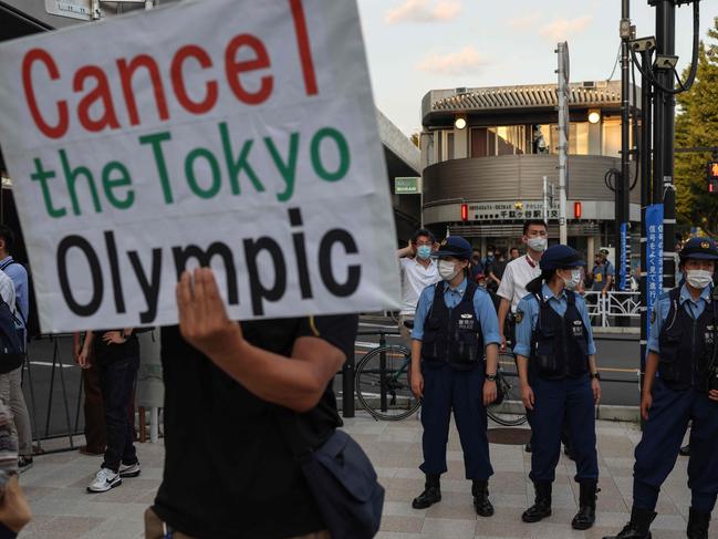 Police officers look on as protesters gather to protest against the Tokyo 2020 Olympic Games near the Olympic Stadium ahead of the opening ceremony. Picture: AFP