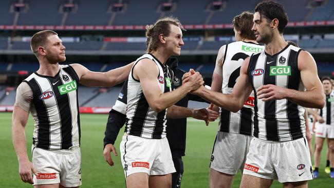 Chris Mayne, middle, is congratulated on his last game by Taylor Adams, left, and Brodie Grundy at the MCG. Jeff Browne wants 11 home games at the famous ground. Picture: Michael Klein