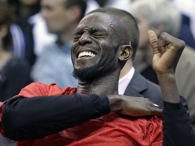 Brooklyn Nets forward Kevin Garnett holds his shoulder while sitting on the bench.