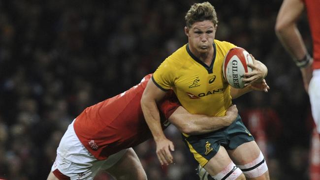 Wallabies captain Michael Hooper tries to escape the arms of a Welsh tackler. Picture: AP