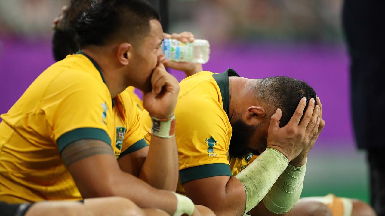 Tolu Latu of Australia looks dejected on the bench with teammates.