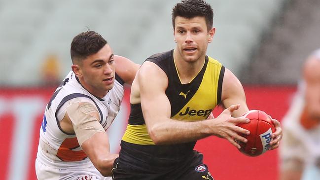 MELBOURNE, AUSTRALIA - JULY 14: Trent Cotchin of the Tigers runs with the ball from Tim Taranto of the Giants during the round 17 AFL between the Richmond Tigers and the Greater Wester Giants at Melbourne Cricket Ground on July 14, 2019 in Melbourne, Australia. (Photo by Michael Dodge/Getty Images)