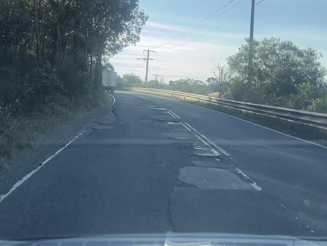 The worst of potholes along the Windy Mile in Diamond Creek, littered in failing patching repairs.