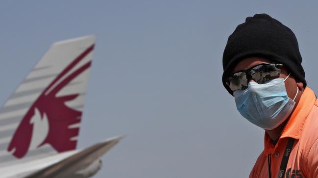 An employee of Qatar Airlines on the tarmac at Hamad International Airport in Doha. The airline is still flying to Australia. Picture: AFP