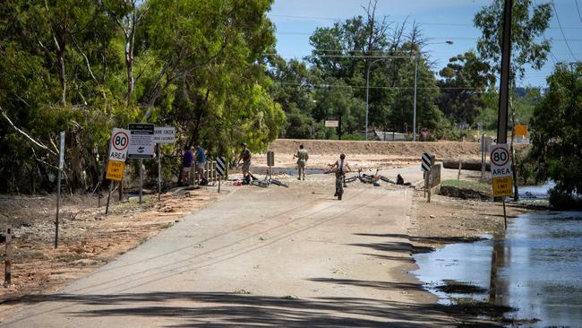 Children ride their bicyles on the damaged 21st Street at Renmark near Bookmark Creek. Picture: Emma Brasier