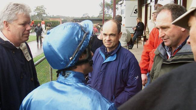 Jon Anderson and Trevor Grant listen to Fabian Alesci chat with trainer Ernie Ewert at a race meeting in Kilmore.