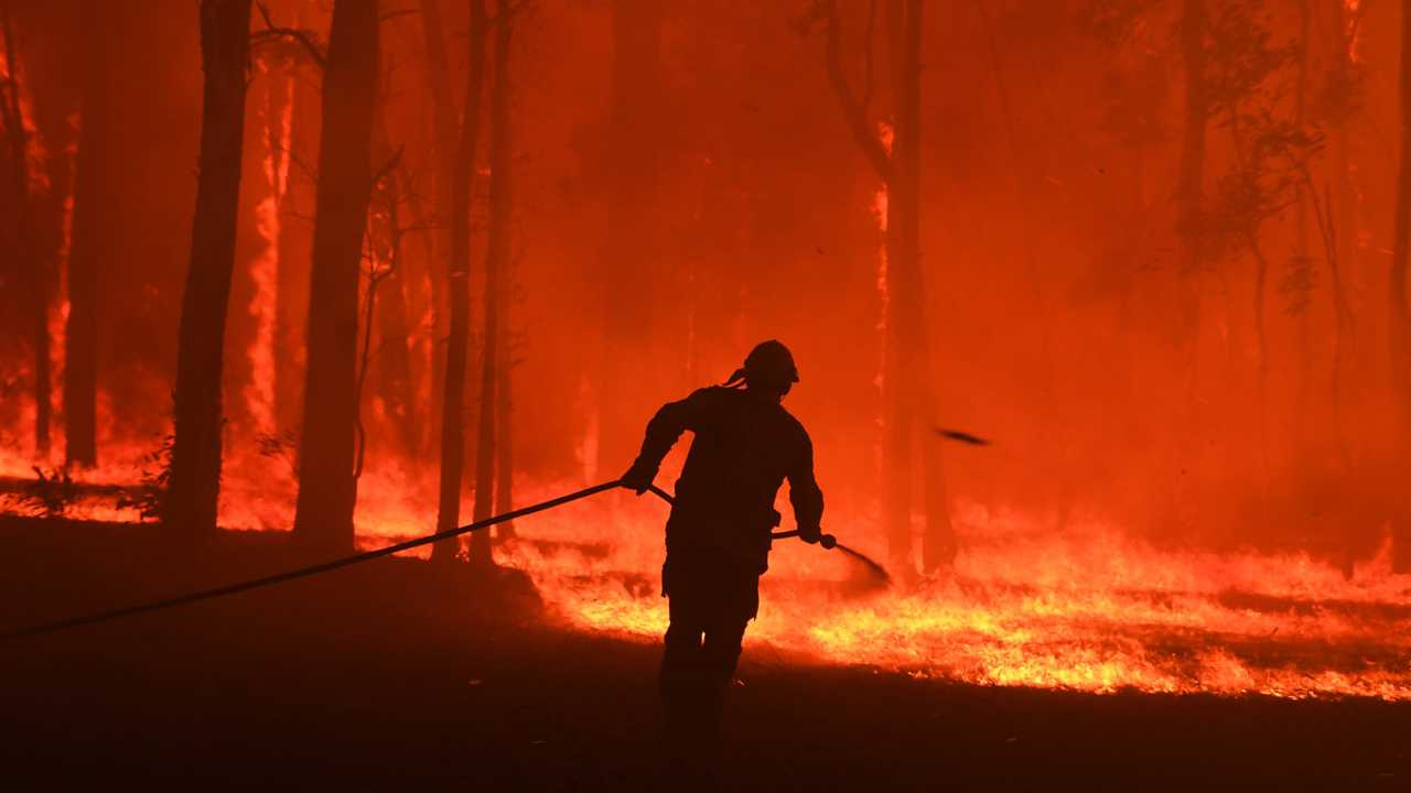 RFS volunteers and NSW Fire and Rescue officers protect a home on Wheelbarrow Ridge Road being impacted by the Gospers Mountain fire near Colo Heights south west of Sydney, Tuesday, November 19, 2019. (AAP Image/Dean Lewins) NO ARCHIVING. Picture: DEAN LEWINS