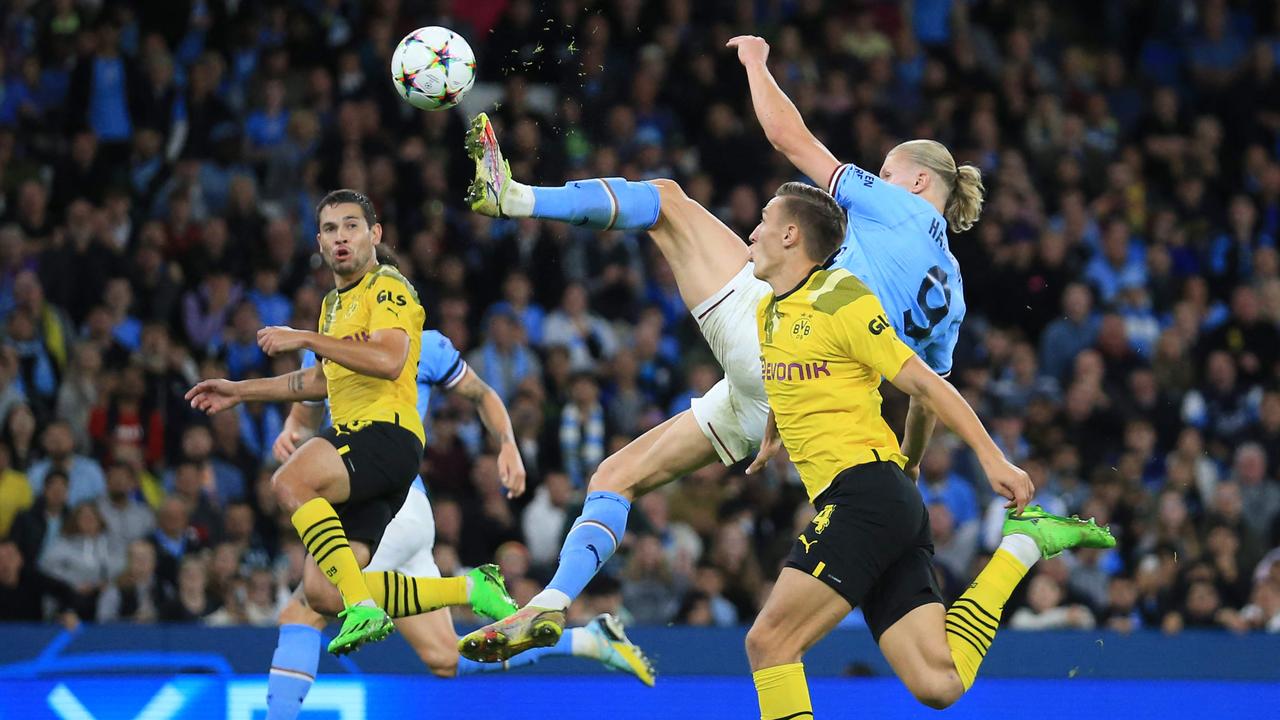 Manchester City's Norwegian striker Erling Haaland (C) shoots to score his team's second goal during the UEFA Champions League group G football match between England's Manchester City and Germany's Borussia Dortmund at the Etihad Stadium in Manchester on September 14, 2022. (Photo by Lindsey Parnaby / AFP)