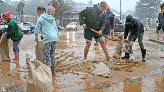 Surf club members, locals &amp; fire fighters laid sandbags to protect the Avoca Beach Surf Club &amp; cafe, as the storm swell threatened to flood them. Picture: Troy Snook