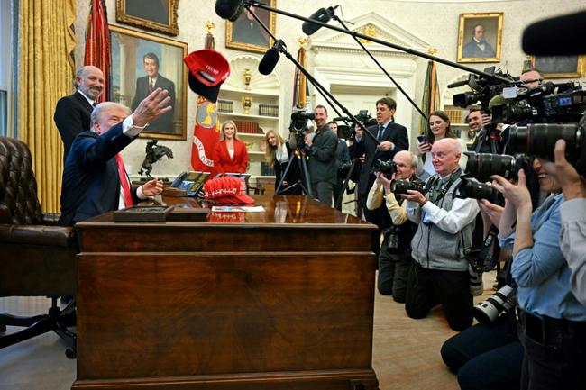 US President Donald Trump throws a hat reading 'Trump was right about everything' after signing an executive order on February 25, 2025