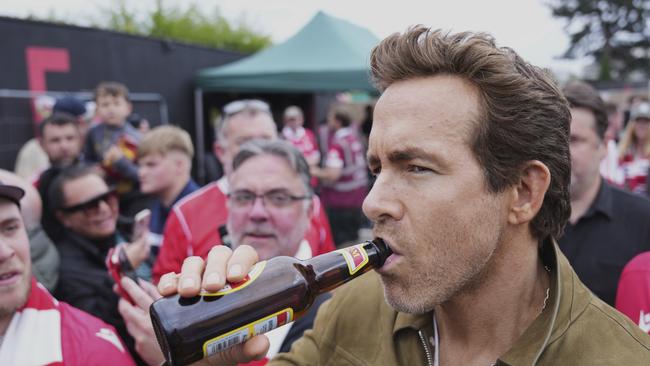 Wrexham co-owner Ryan Reynolds sips beer prior to the game. AP Photo/Jon Super.