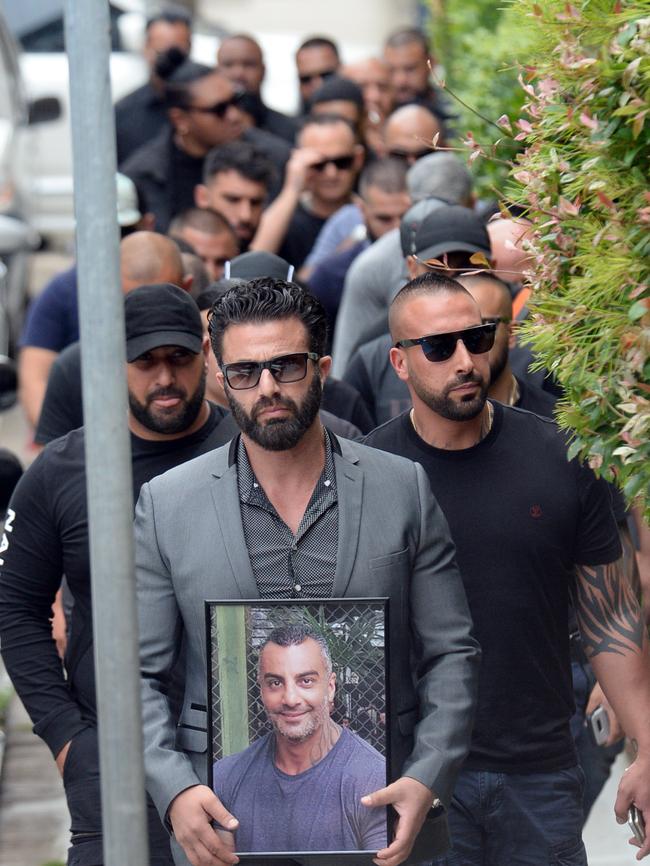 Mourners arrive with a framed photo of Mahmoud Hawi. Picture: Jeremy Piper