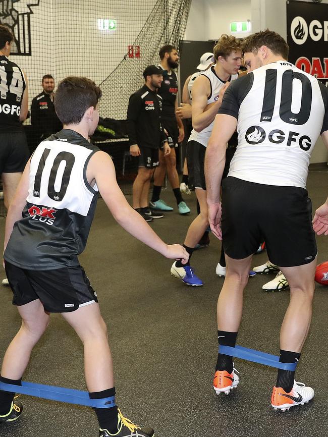 Boaky’s Buddy, Ryan Lane-Ellis stretches with former Port Adelaide captain Travis Boak at Alberton Oval on Tuesday. Picture SARAH REED