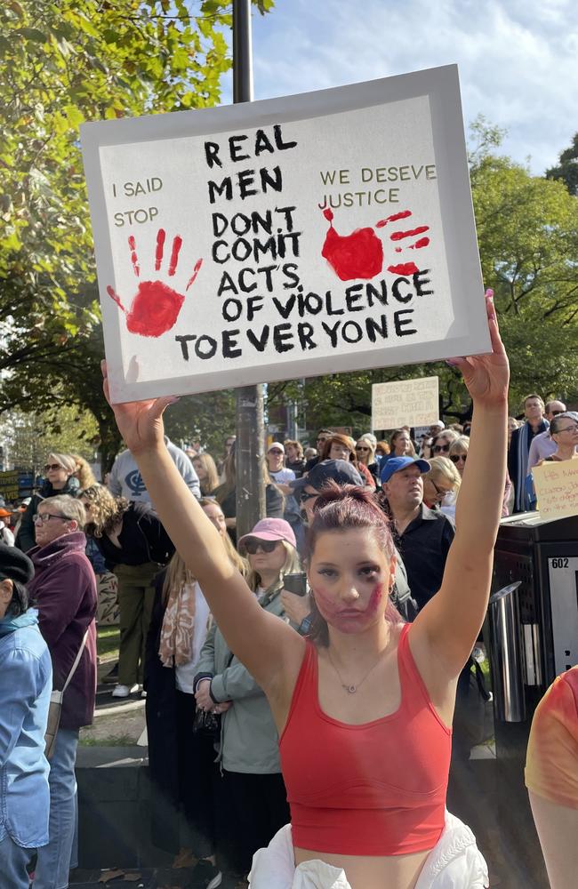 A woman holding a sign with a powerful message.