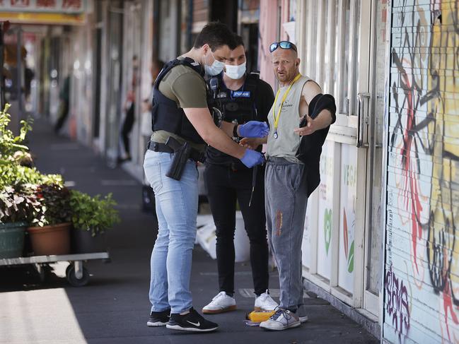 Police question a man during the operation. Picture: Alex Coppel