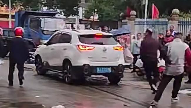 This frame grab taken from video footage circulating on Chinese social media on November 19, 2024 shows the scene where a car crashed outside the Yong'an primary school in Changde, central China's Hunan province, in which "multiple students were injured" according to state-run media. Multiple children were injured on November 19 when a car crashed outside a primary school in central China, state media said, without providing more details about the number of casualties or the person responsible. Footage circulating on Chinese social media -- which matched online images of the school -- appeared to show the aftermath of the incident, with dozens of children running in panic away from the site of the crash yelling "help, help". (Photo by social media / AFP) / China OUT / RESTRICTED TO EDITORIAL USE - MANDATORY CREDIT "AFP PHOTO / CHINESE SOCIAL MEDIA" - NO MARKETING NO ADVERTISING CAMPAIGNS - DISTRIBUTED AS A SERVICE TO CLIENTS - NO ARCHIVE