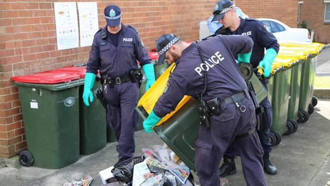 Police sift through rubbish at a Maroubra property yesterday, searching for clues to last week’s stabbing murder of homeless man Peter Hoffman, 68.