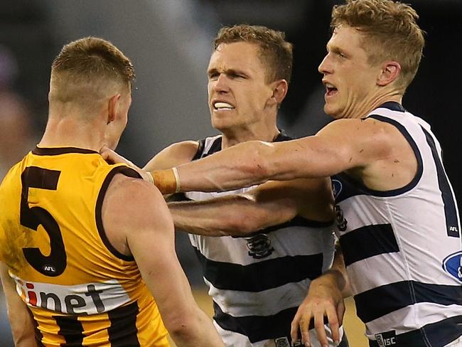 Sam Mitchell goes toe-to-toe with Cats Joel and Scott Selwood. Picture: Wayne Ludbey