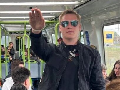 A white supremacist performs the salute on a busy Melbourne train.