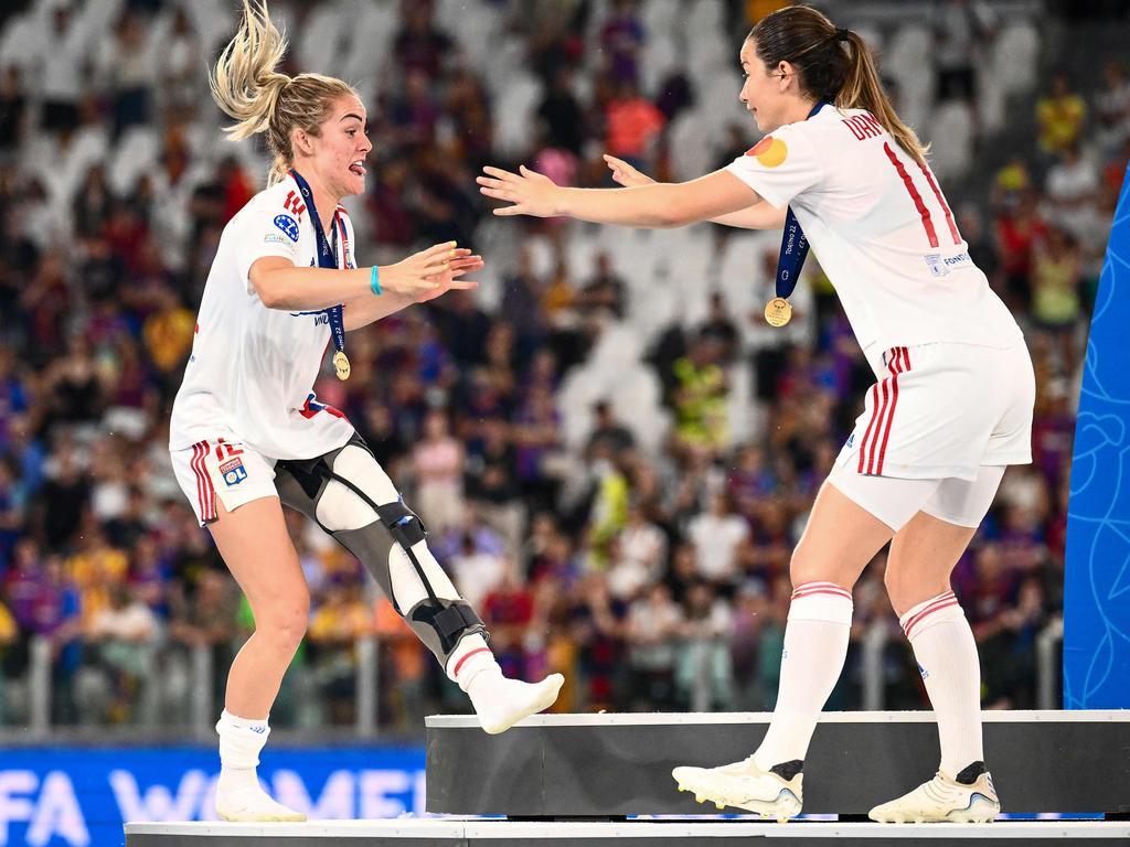 Lyon's Australian defender Ellie Carpenter and Dutch midfielder Damaris Egurrola celebrate on the podium after their team won the UEFA Women’s Champions League final over Barcelona in Turin. Picture: Marco Bertorello/AFP