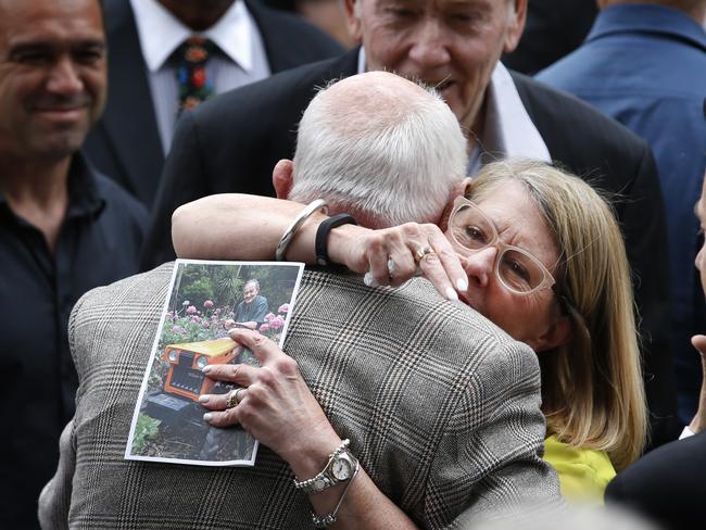 A mourner hugs Co-owner of Pellegrini's Espresso Bar Nino Pangrazio outside after the service. Picture: David Caird