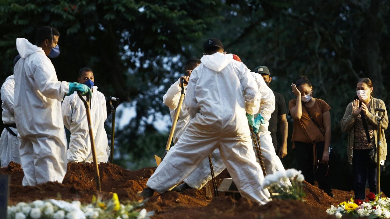 Gravediggers work through the night in Brazil. Picture: Miguel Schincariol/AFP