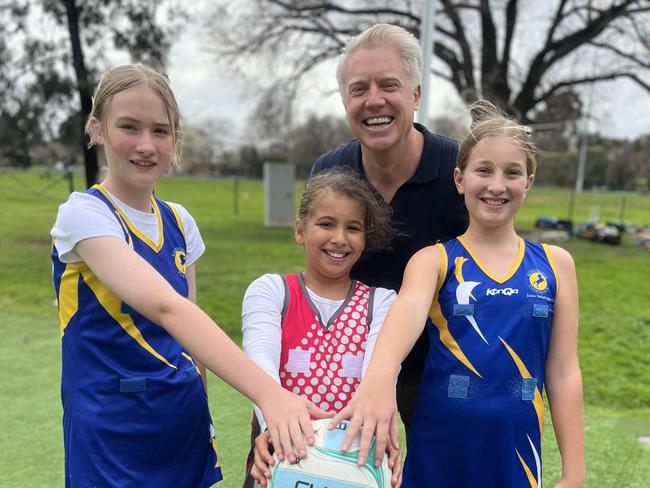 Aaron Wood with young netballers Charley, Arabella and Lila.