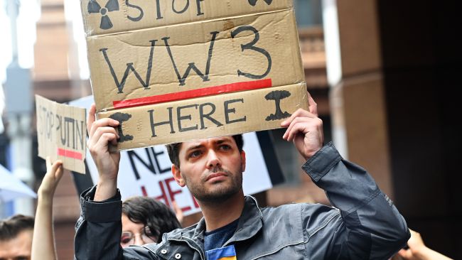A protester holding a sign calling to "stop WW3". Picture: NCA NewsWire / Jeremy Piper