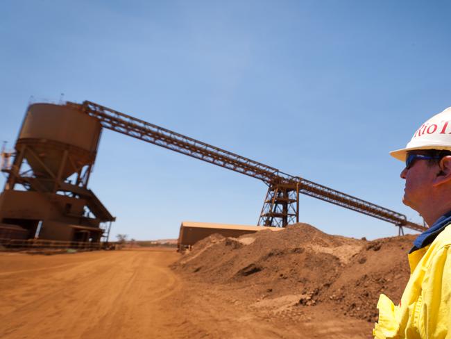 A mine worker looks at a train loader at Rio Tinto Group's West Angelas iron ore mine in Pilbara, Australia, on Sunday, Feb. 19, 2012. Rio Tinto Group, the world's second-biggest iron ore exporter, will spend $518 million on the first driverless long-distance trains to haul the commodity from its Western Australia mines to ports, boosting efficiency. Photographer: Ian Waldie/Bloomberg