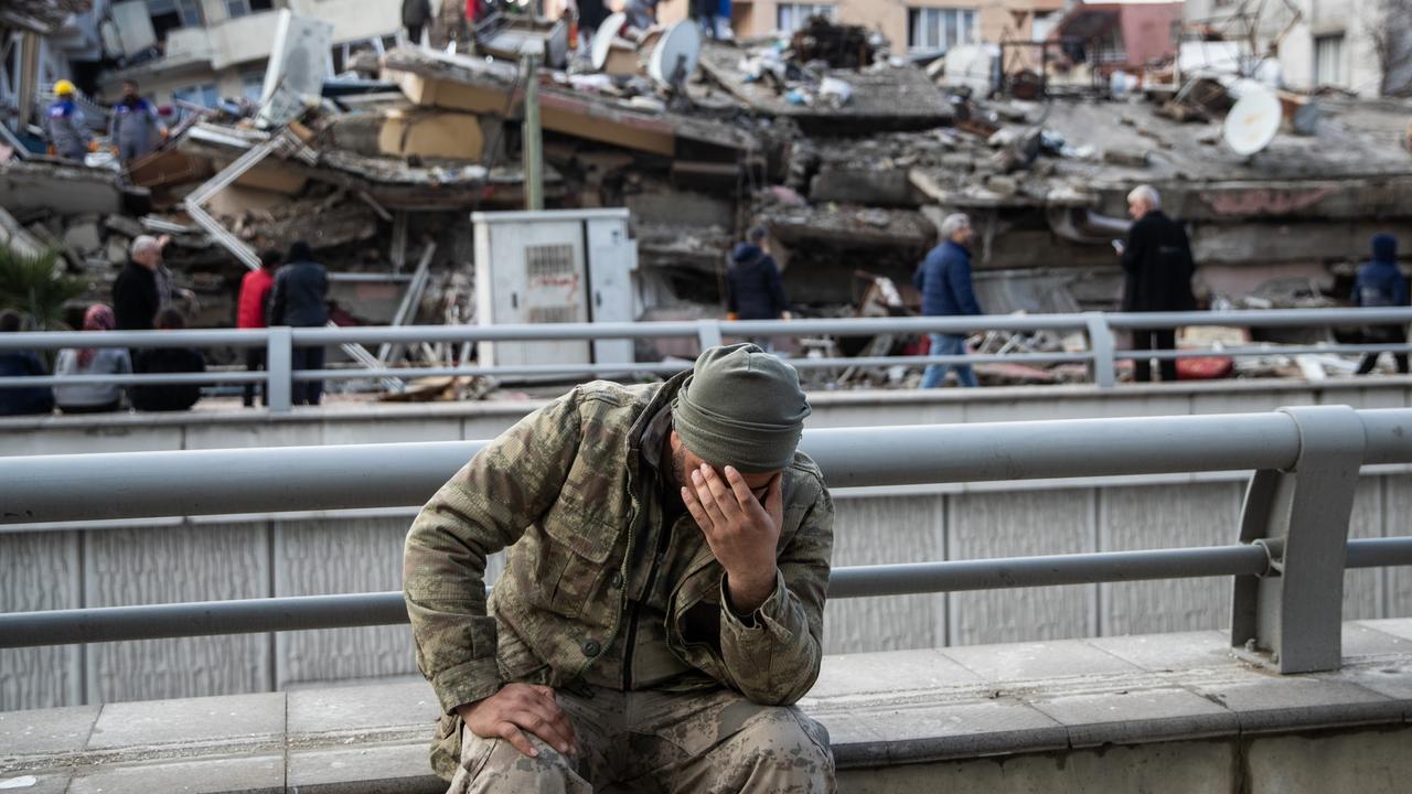A soldier sits devastated near the collapsed building. (Photo by Burak Kara/Getty Images)