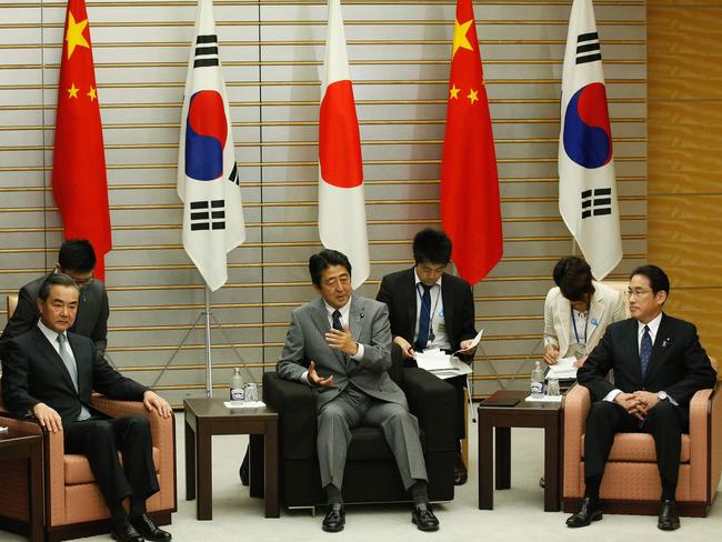 Japanese Prime Minister Shinzo Abe (2nd from R), South Korean Foreign Minister Yun Byung-Se (L), Chinese Foreign Minister Wang Yi. Picture: AFP.