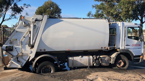 A garbage truck has got stuck in a sinkhole in Namona St, Narrabeen. Picture: Jim O'Rourke.