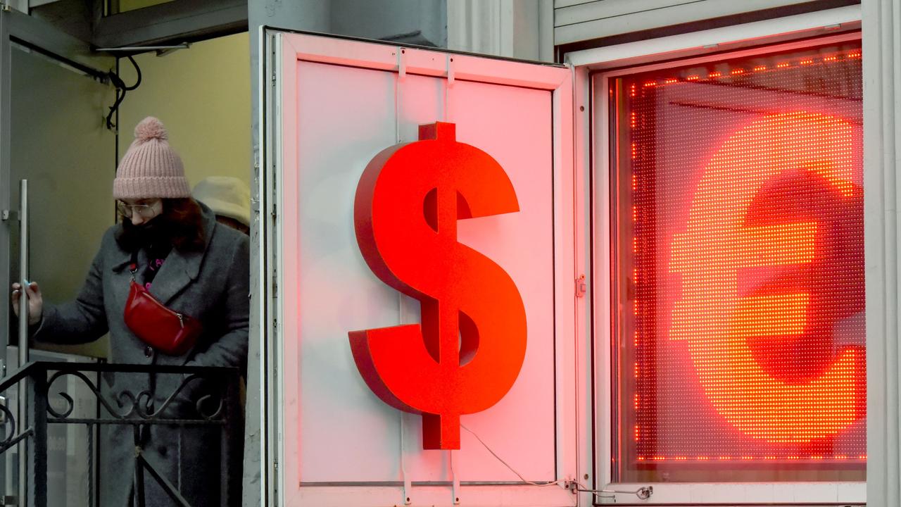 A woman leaves a currency exchange office displaying the US dollar and the euro signs in Saint Petersburg on March, 2, 2022. Picture: AFP