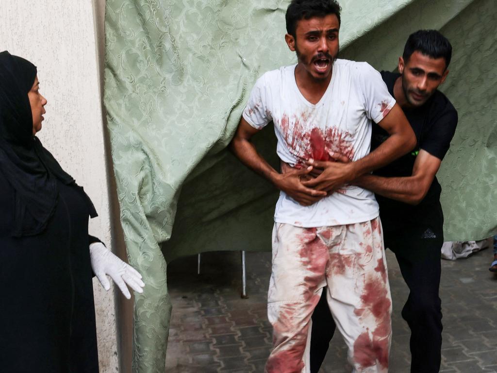 A blood-covered man reacts after recognising a person killed in an Israeli strike, outside a makeshift morgue in Rafah in the southern Gaza Strip. Picture: AFP