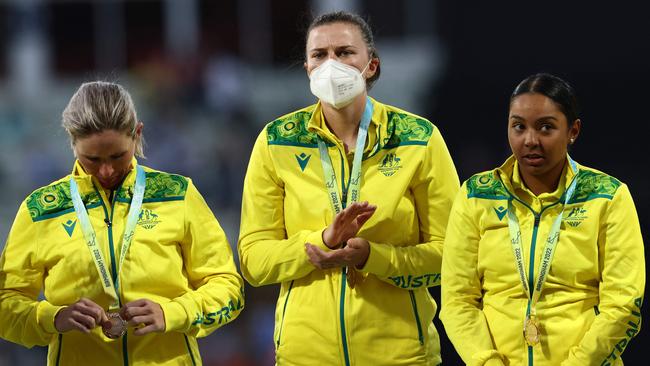 Gold medalists team Australia, including Australia's Tahlia McGrath (C) wearing a face mask, on the podium during the medal ceremony. Picture: Darren Staples / AFP