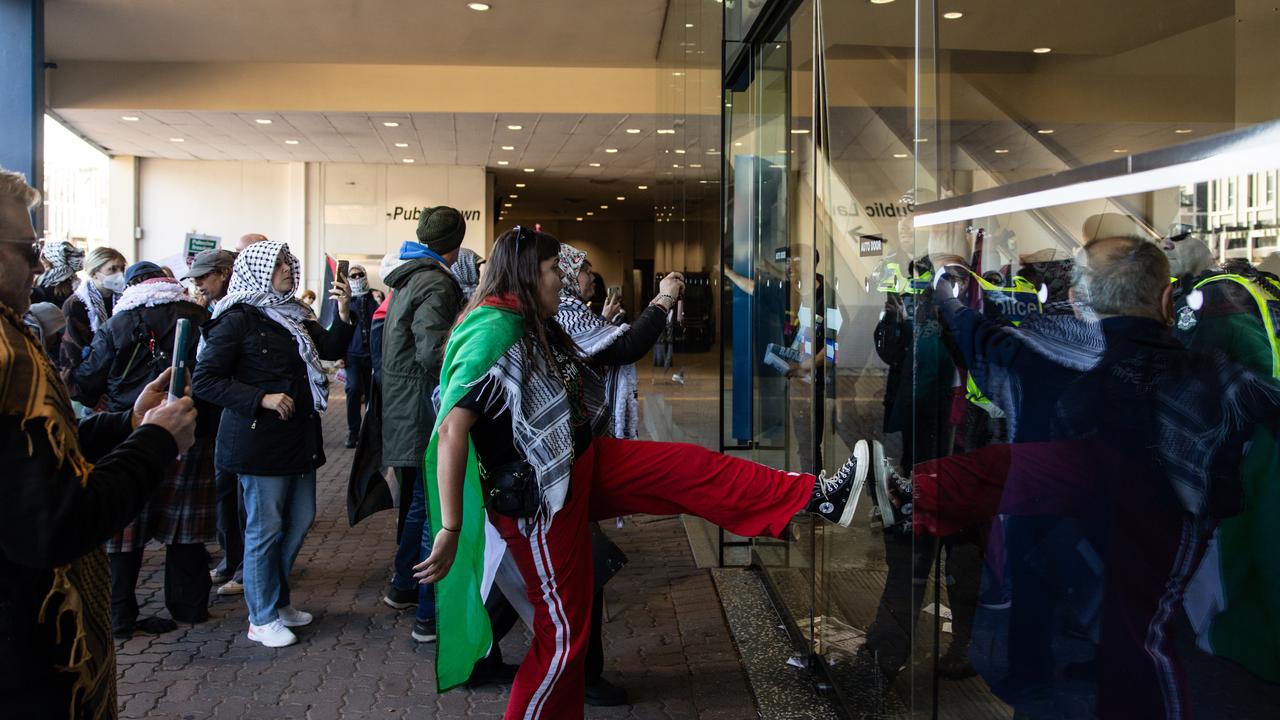 Pro-Palestine protesters kick the main entrance the ALP Conference occurs inside. Picture: NCA NewsWire / Diego Fedele