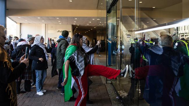 Pro-Palestine protesters kick the main entrance the ALP Conference occurs inside. Picture: NCA NewsWire / Diego Fedele