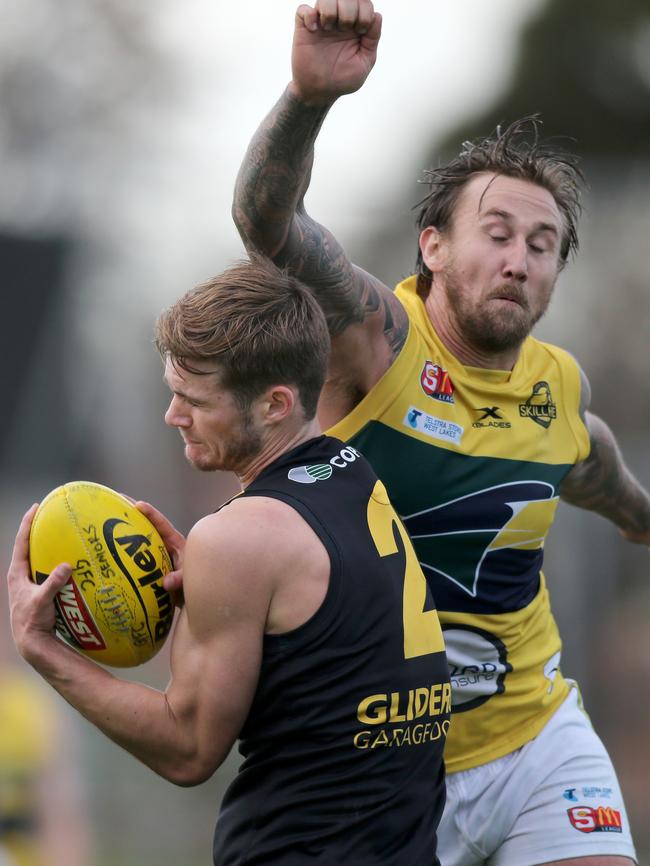 Come on Scotty, use some deodorant. Glenelg's Jonty Scharenberg marks under pressure from Eagle's Scott Lewis. Picture: Dean Martin/AAP