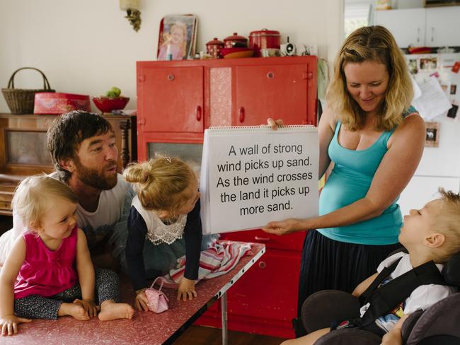 Roki Mill's mum Ina teaching Roki to read at their family home in Newport. With dad Dave and sisters Ruby, 5 and Rosie, 1. Picture: twolittlebirdsphotography.com.au.