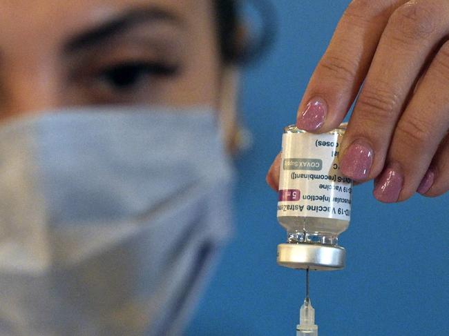 A member of the Armed Forces prepares a dose to vaccinate colleagues against the novel coronavirus COVID-19 with the AstraZeneca/Oxford vaccine obtained through the Covax scheme, at the CCK Cultural Centre in Buenos Aires on June 15, 2021. (Photo by Juan MABROMATA / AFP)