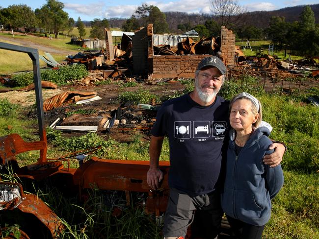 Martin Wraight and partner Rebecca Sloane stand in front of the rubble of their burnt down home near Galba, Cobargo. Picture: Toby Zerna