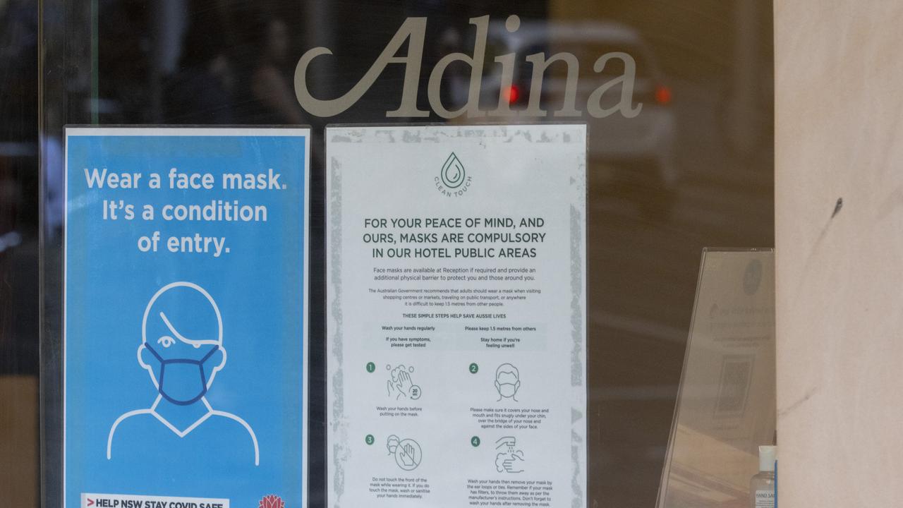 A face mask usage sign on the door of the Adina hotel in Sydney. Picture Jenny Evans/Getty Images