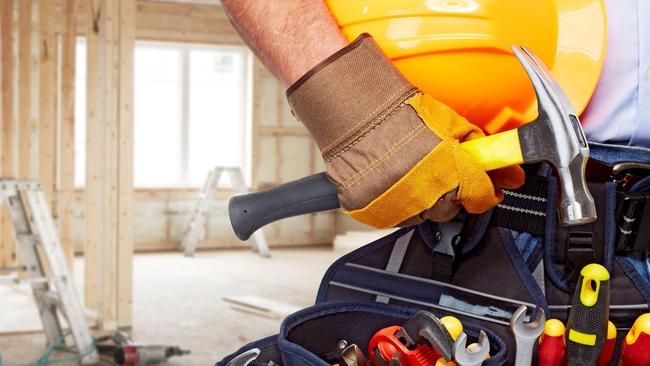 Builder handyman with construction tools. House renovation background.