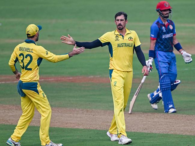 Australia's Mitchell Starc (C) celebrates with teammate Glenn Maxwell (L) after taking an Afghanistan wicket during the 2023 ICC Men's Cricket World Cup. Picture: Indranil Mukukherjee / AFP