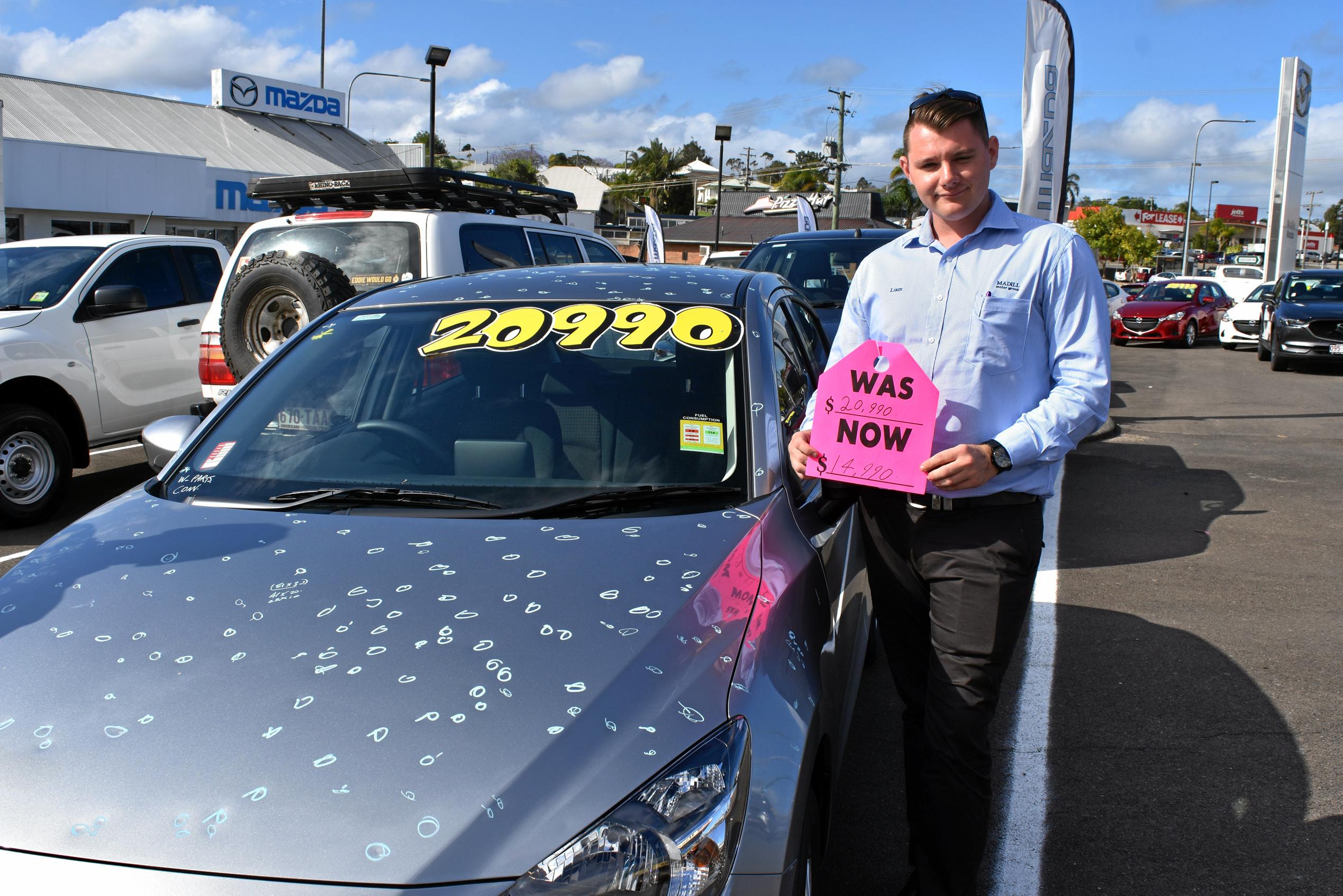 Liam Smith with one of the hail damaged cars at Madills Mazda. Picture: DONNA JONES