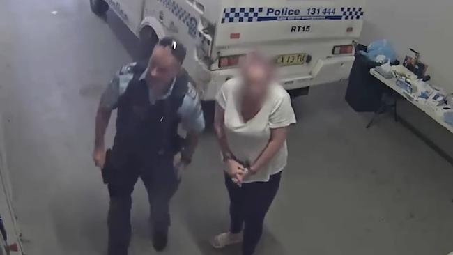 Georgie Marks, 41, being taken inside Raymond Terrace police station to be charged with wound person with intent to cause grievous bodily harm. Picture: NSW Police.