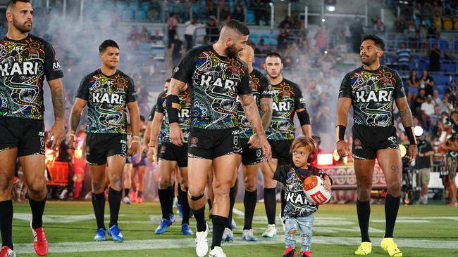 Quaden Bayles leads the Indigenous All Stars on to the field with captain Joel Thompson. Picture: AAP